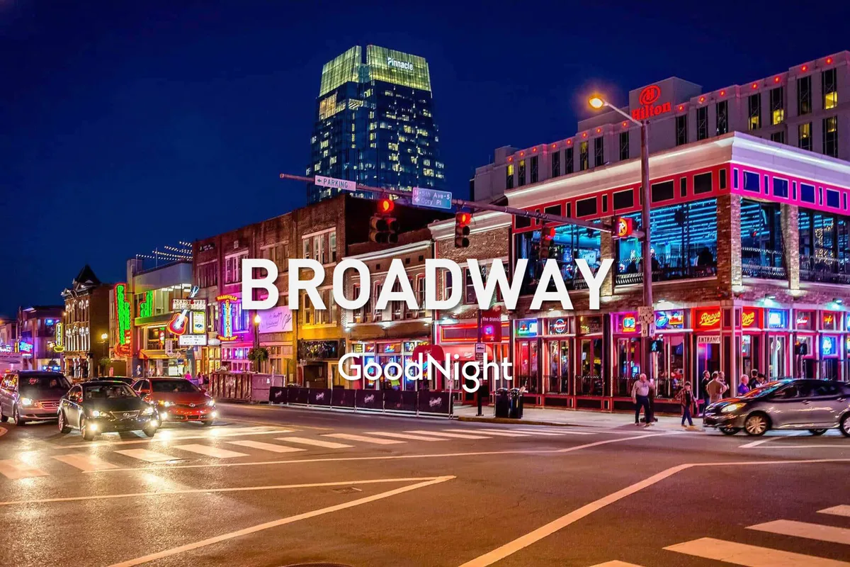 A bustling Nashville street scene at night, filled with neon signs, people walking, and cars in motion. The energy of the nightlife is palpable, hinting at live music venues and late-night dining along the Broadway strip.