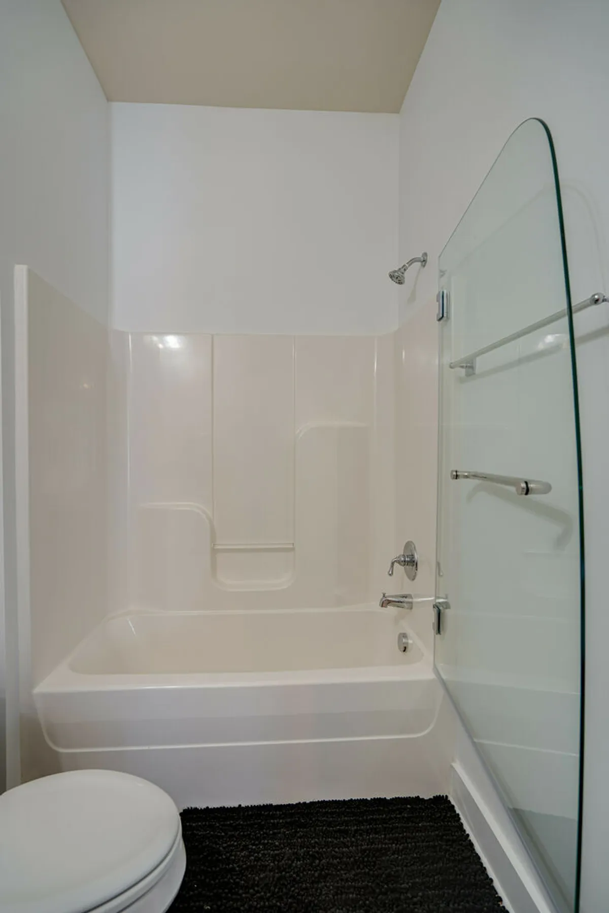 A modern bathroom with a glass-enclosed shower and a large soaking bathtub, evoking a spa-like feel. The clean lines, bright ambiance, and quality fixtures create a space ideal for relaxation and self-care.